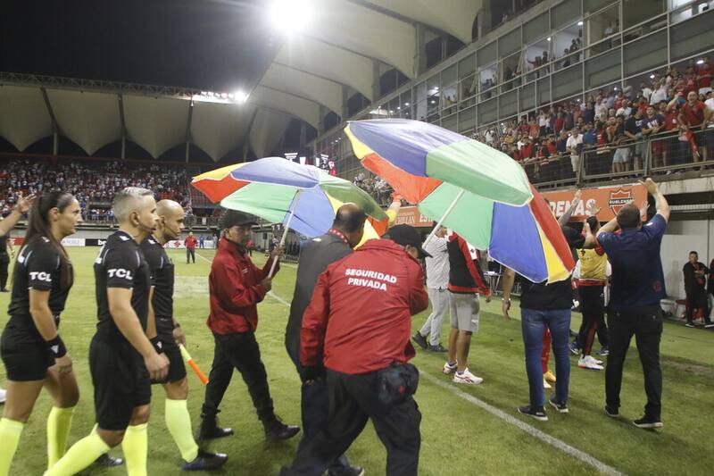 El cuerpo arbitral tuvo que salir del campo de juego con resguardos. Foto: Aton.