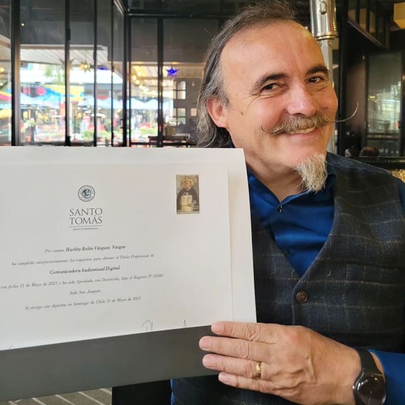 Paul Vásquez, "El Flaco", sosteniendo el diploma de su hija.