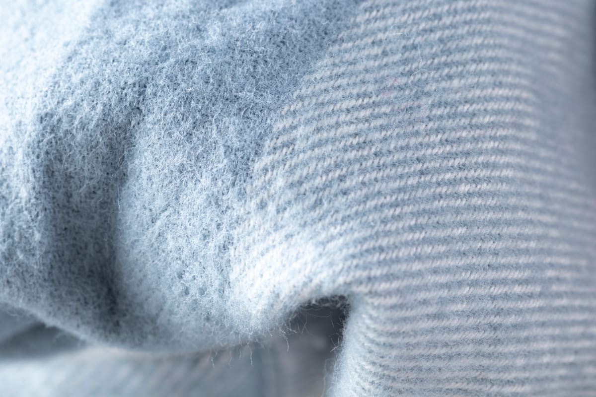 Debido al uso o si tenemos mascotas, sus pelos y pelusas pueden quedarse pegados en nuestras prendas. Créditos: Freepik.