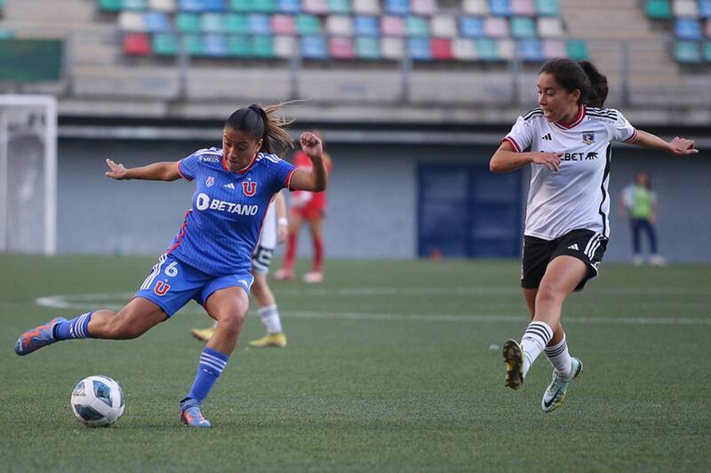 Imagen del partido del partido de la primera fase, en que la jugadora de Universidad de Chile Llanka Groff golpea el balón ante la presencia de la colocolina Yastin Jiménez.