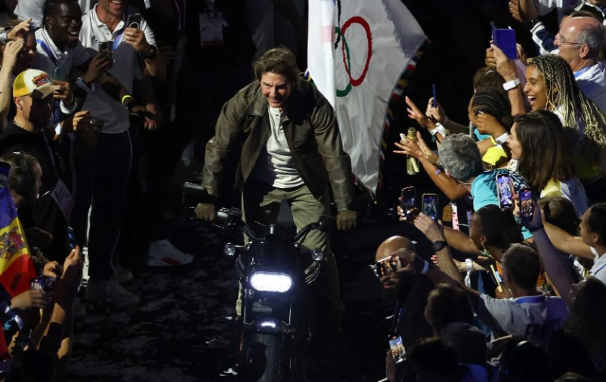 Así se despedió el público francés de Tom Cruise al salir con su motocicleta con la bandera olímpica.