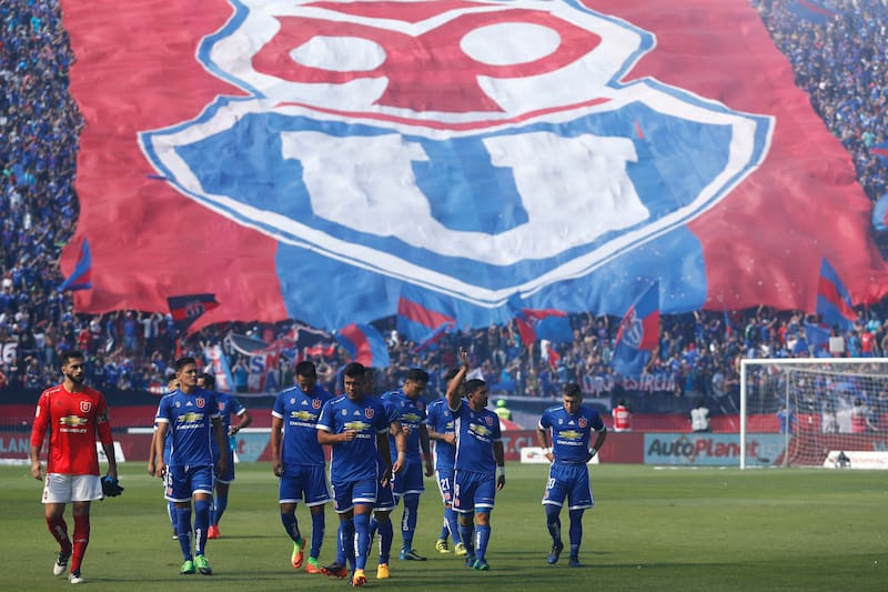Hinchas de Universidad de Chile alientan a su equipo en el Estadio Nacional.