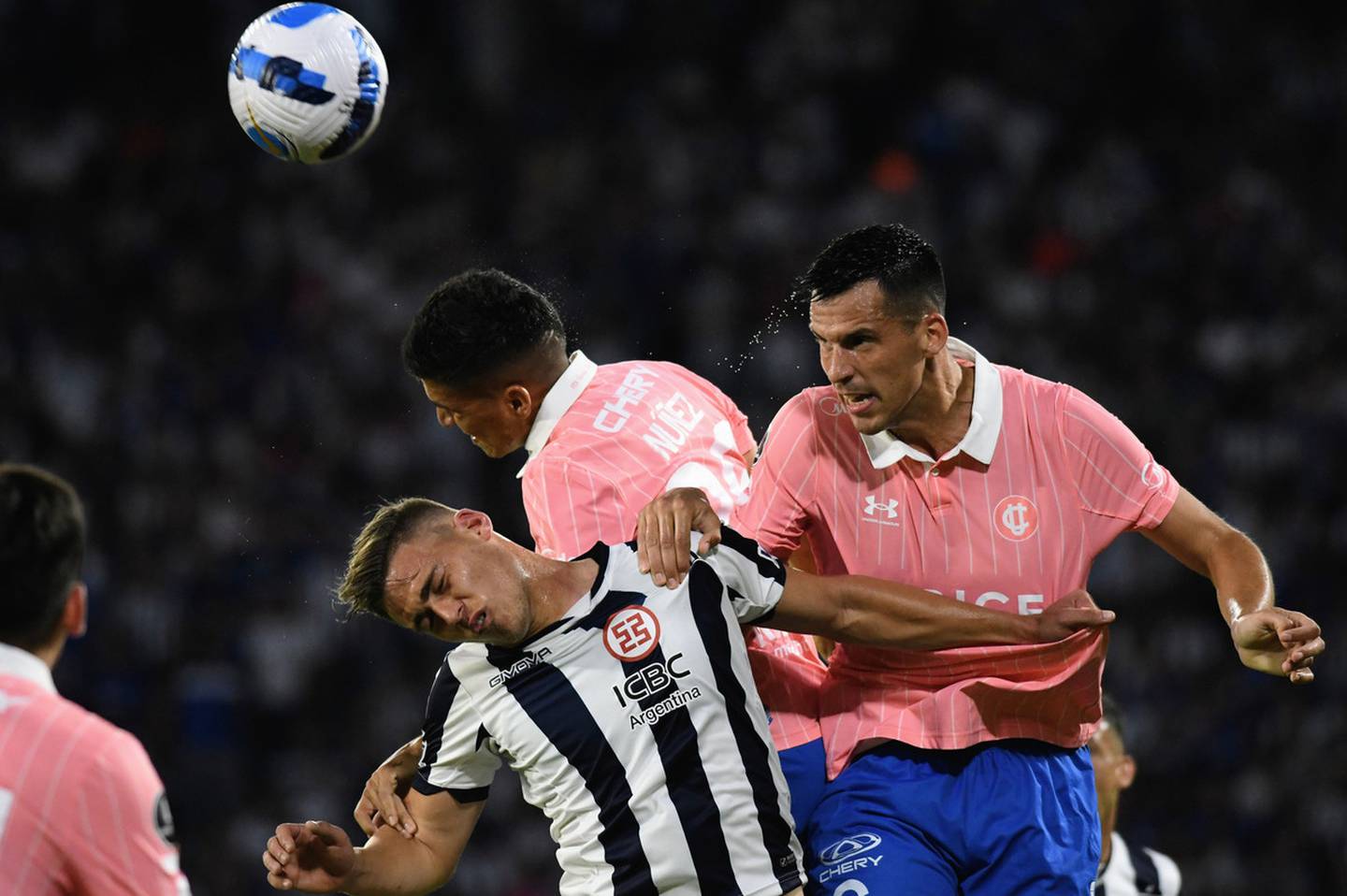 El defensa argentino Nehuén Paz salta para cabecear una pelota durante el partido de la Universidad Católica y Talleres en la Copa Libertadores.